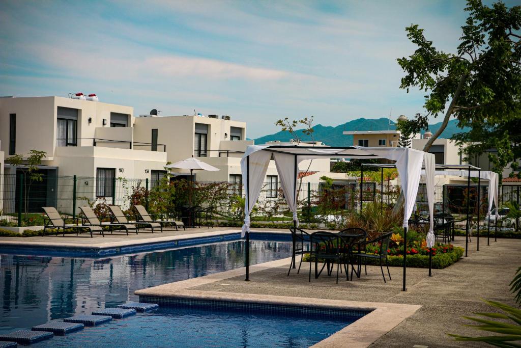 een zwembad van het hotel met stoelen en een tafel bij Casa Mayawell in Las Juntas
