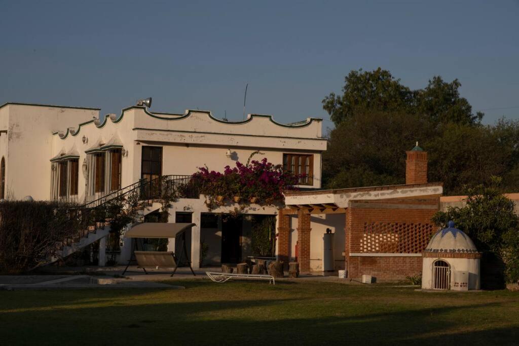 a white house with a staircase and a building at Las Linas in Tequisquiapan