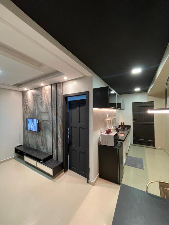 uma grande cozinha com uma porta preta e um fogão em Apto Moderno - Centro em Macapá