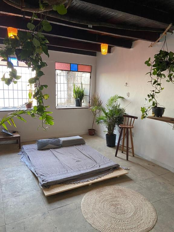 een bed in een kamer met potplanten en ramen bij suite com vista mar in Salvador