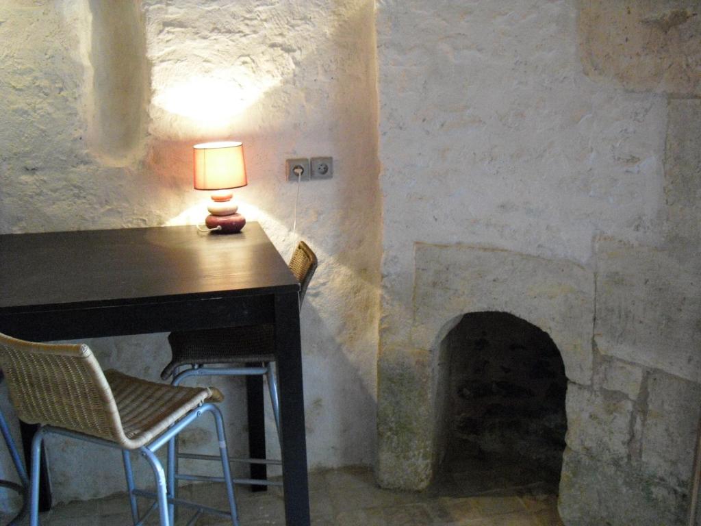 a table with a lamp on a table with a fireplace at Moulin De Chez Renaud in Sousmoulins