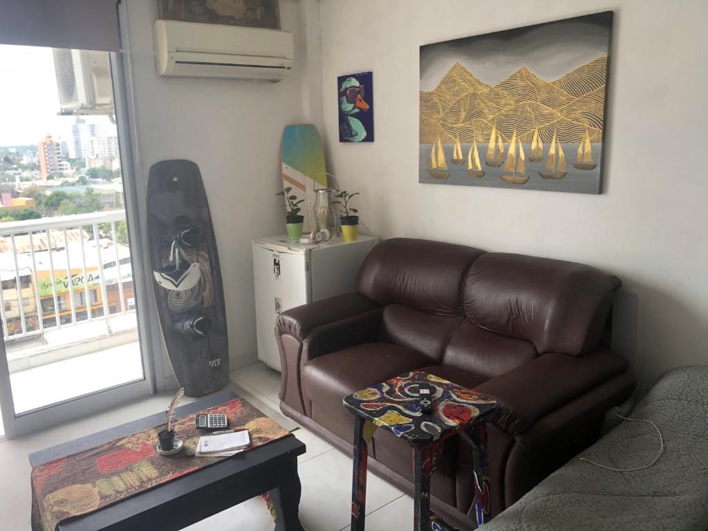 a living room with a leather couch and a table at Solar in Resistencia