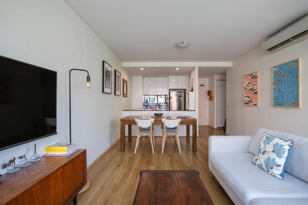 a living room with a white couch and a table at Treetops Erskineville Apartment w Parking & Aircon in Sydney