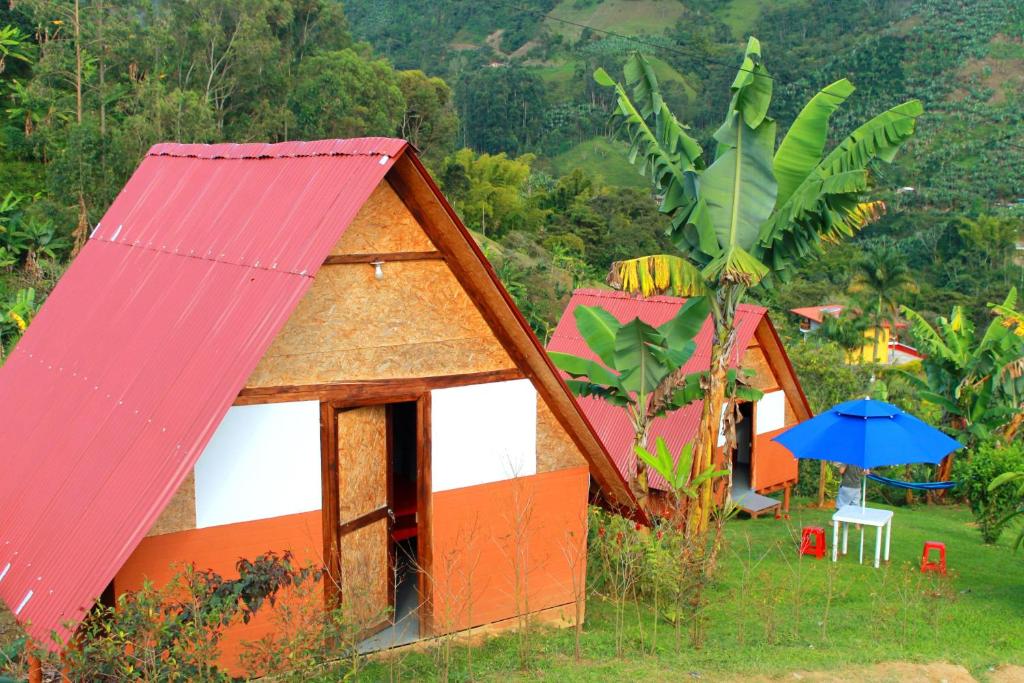 un grupo de casas con techo rojo y sombrilla en Cabañas Villa Loe, en Jardín
