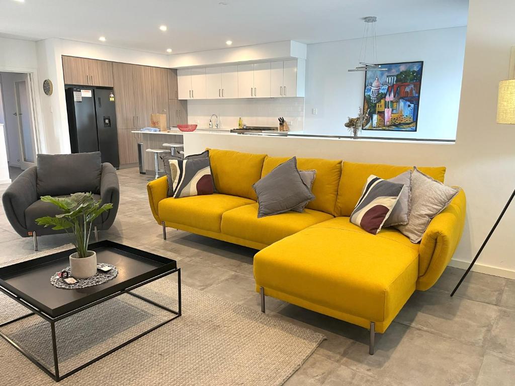 a living room with a yellow couch and a table at 2 Chic Stylish Modern Family On Charles in Perth