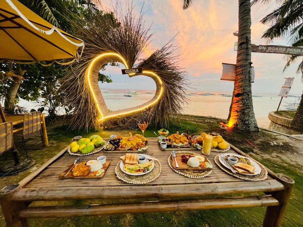 einen Tisch mit Essen drauf mit herzförmigem in der Unterkunft On Board Panglao Beach Hostel & Resort in Dao