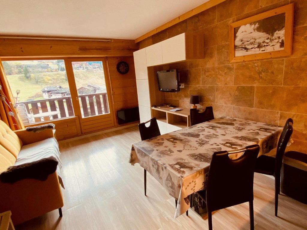 une salle à manger avec une table et un balcon dans l'établissement Appartement moderne centre village avec balcon et garage - FR-1-459-222, à La Clusaz