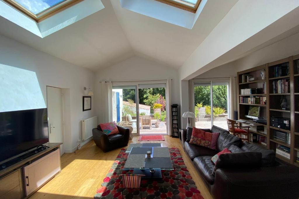 un salon avec un canapé et une télévision dans l'établissement Sumptuous house with pool, à La Rochelle