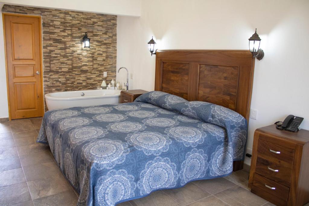 een slaapkamer met een bed en een bad bij Hotel Boutique Casa Tellez 