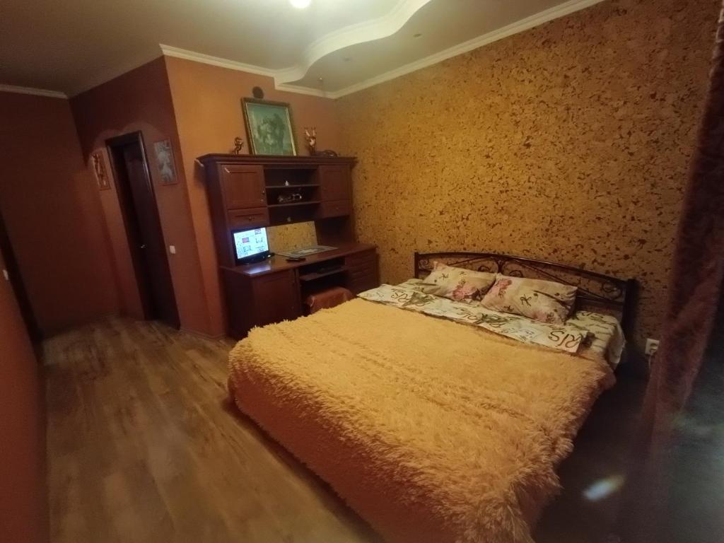 1 dormitorio con 1 cama y TV en Апартаменти район КРЕСа Сичеславська33 ''3кімн і 1кімн'' і Свирська1 "2кімн", en Krivoy Rog