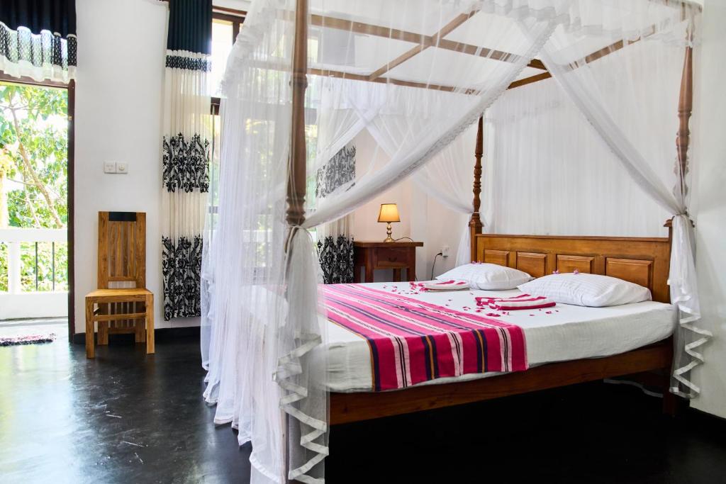 a bedroom with a bed with a canopy at Daasa Guest Mirissa in Mirissa