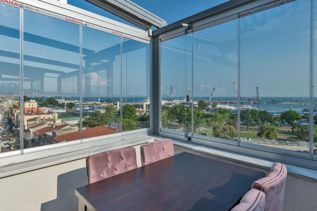 a table and chairs in a room with large windows at Matiat Hotel Istanbul in Istanbul