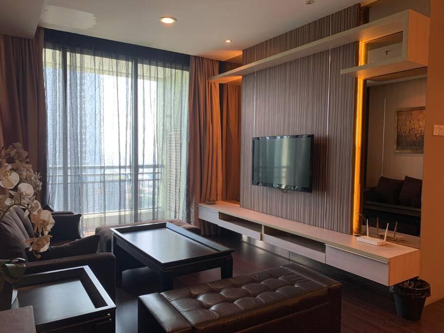 a living room with a couch and a television on a wall at 2br- Central Park Residence Alaina Tower Floor 29 in Jakarta