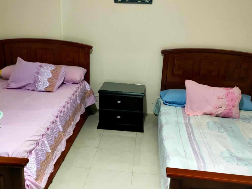 dos camas sentadas una al lado de la otra en una habitación en Private Room with private bathroom in a cozy Apt. And shared area en El Cairo