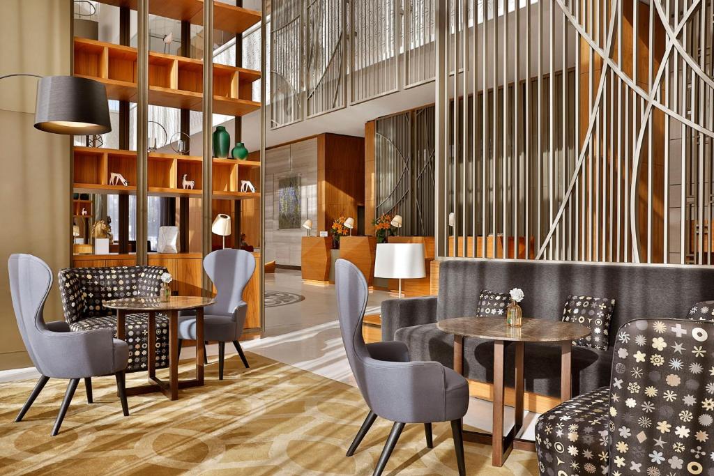 - un restaurant avec des tables et des chaises dans une salle dans l'établissement Sheraton Astana Hotel, à Astana