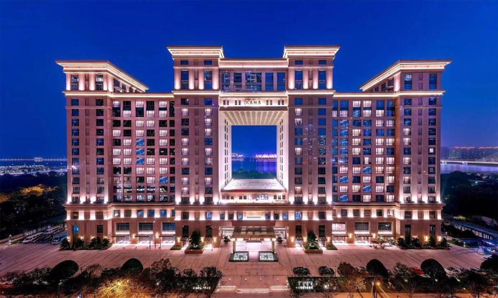 a large building with a lit up facade at night at JiuTai Hotel Hangzhou in Hangzhou