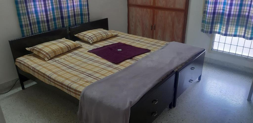 a bed with a blanket and pillows on it at GG Homes - Apollo/Shankara Hospital in Chennai