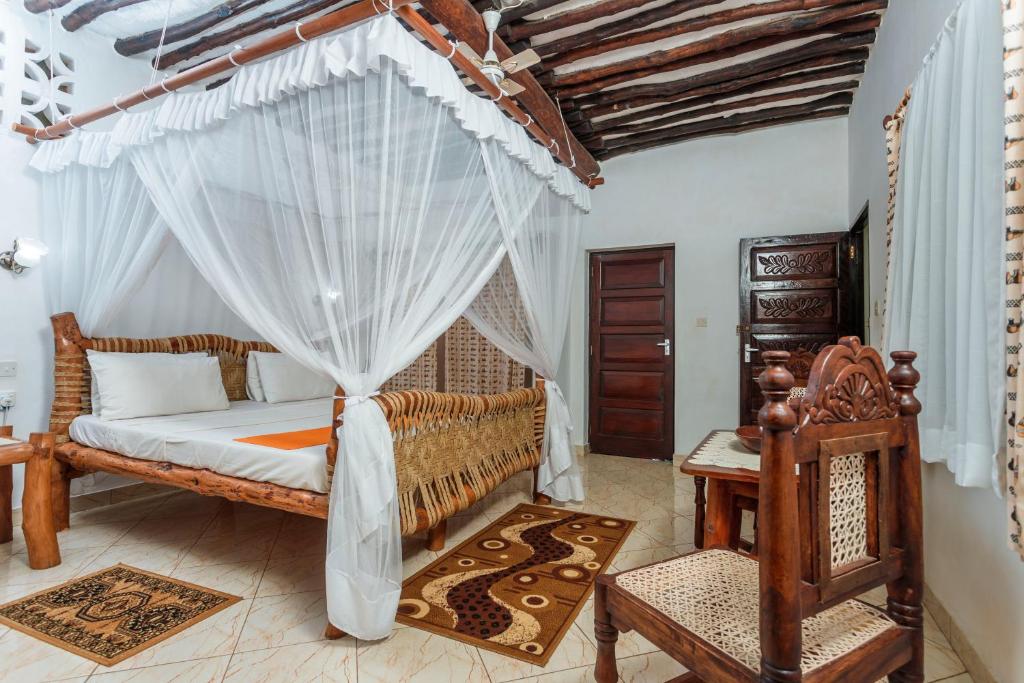una camera con letto e zanzariera di Diani Beach-Villa Kirsch a Galu