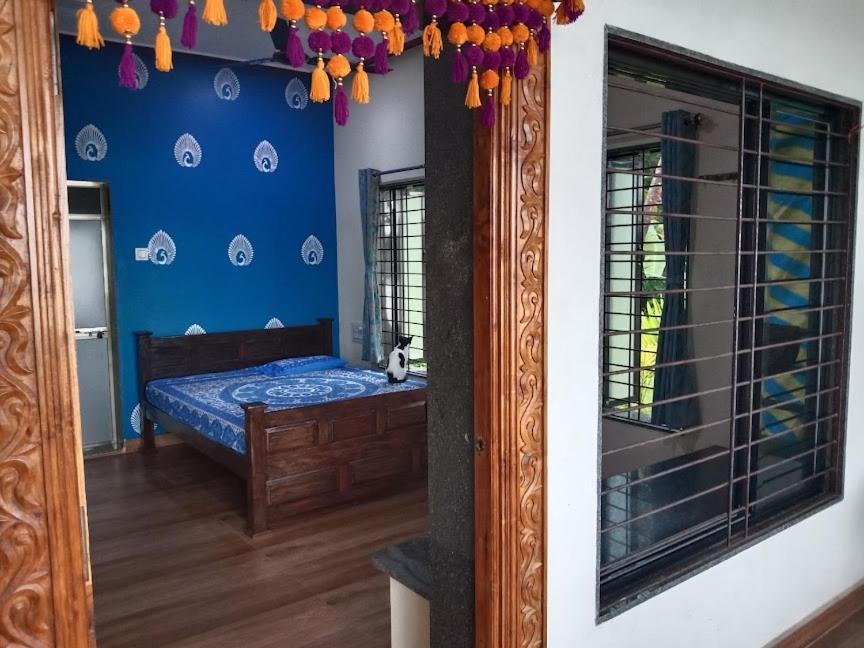 a bedroom with a mirror and a bed in it at Korjai kinara Homestay in Malvan
