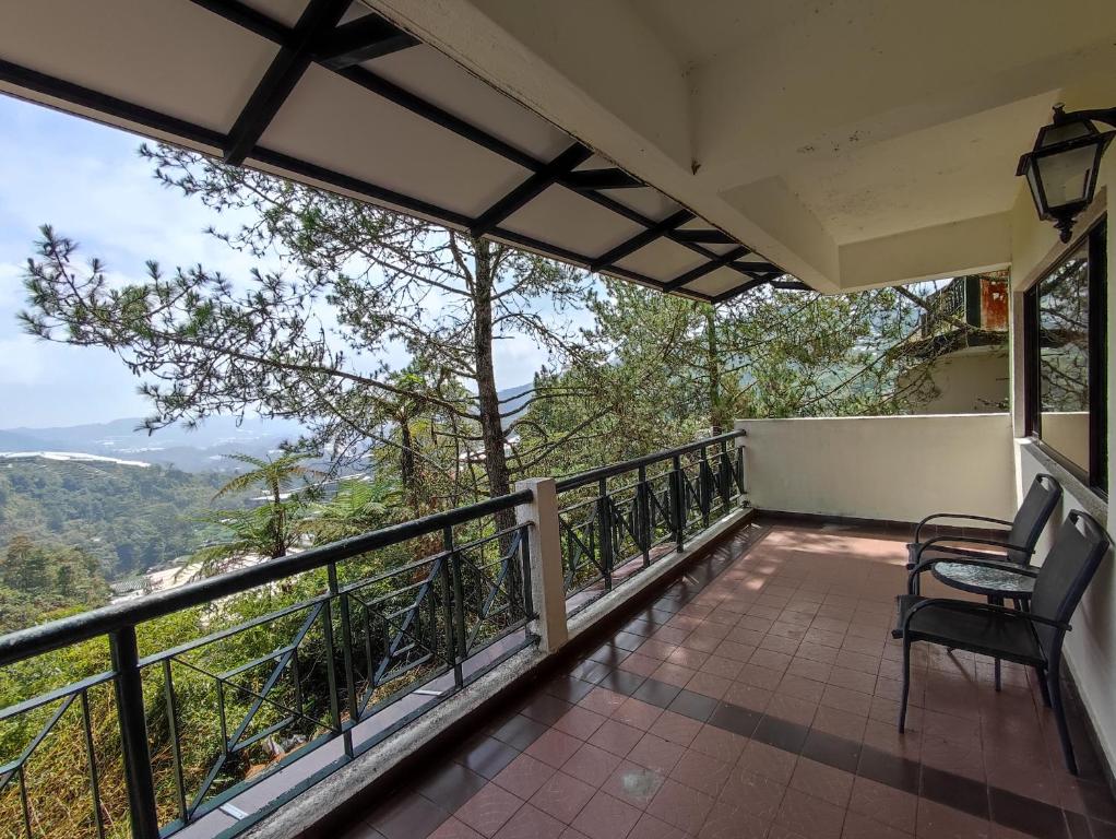 a balcony with chairs and a view of the mountains at Sunrise View One Bedroom Apartment at Equatorial Hill Resort in Brinchang