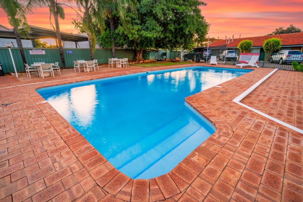 a large blue swimming pool with a brick patio at Hospitality Kalgoorlie, SureStay Collection by Best Western in Kalgoorlie