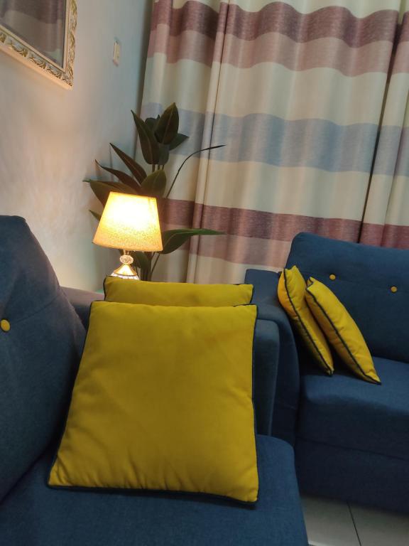 セパンにあるBunga Homestay KLIA Sepangの青いソファ(黄色の枕、ランプ付)