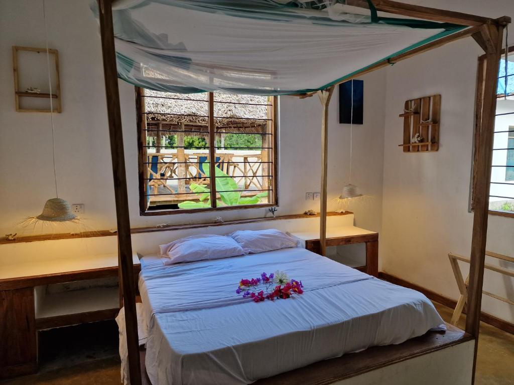 a bedroom with a bed with flowers on it at Mafia Island Bungalows in Utende