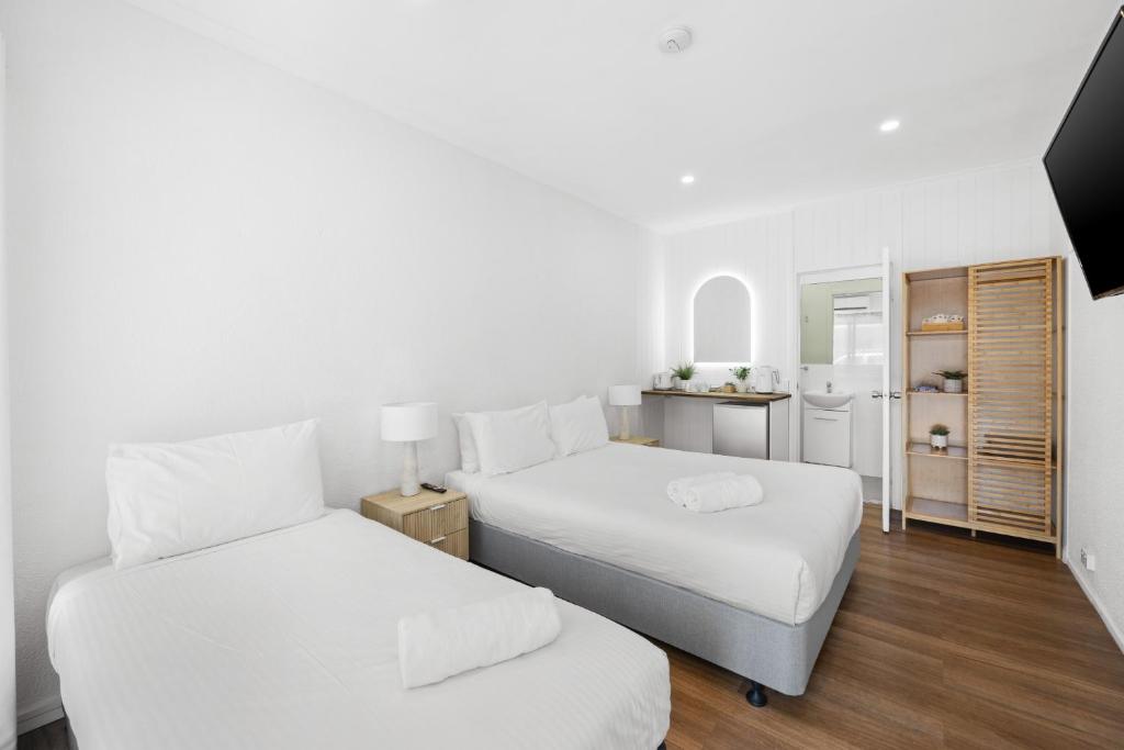 a bedroom with two beds and a kitchen at Central Motel Mooloolaba and Apartments in Mooloolaba