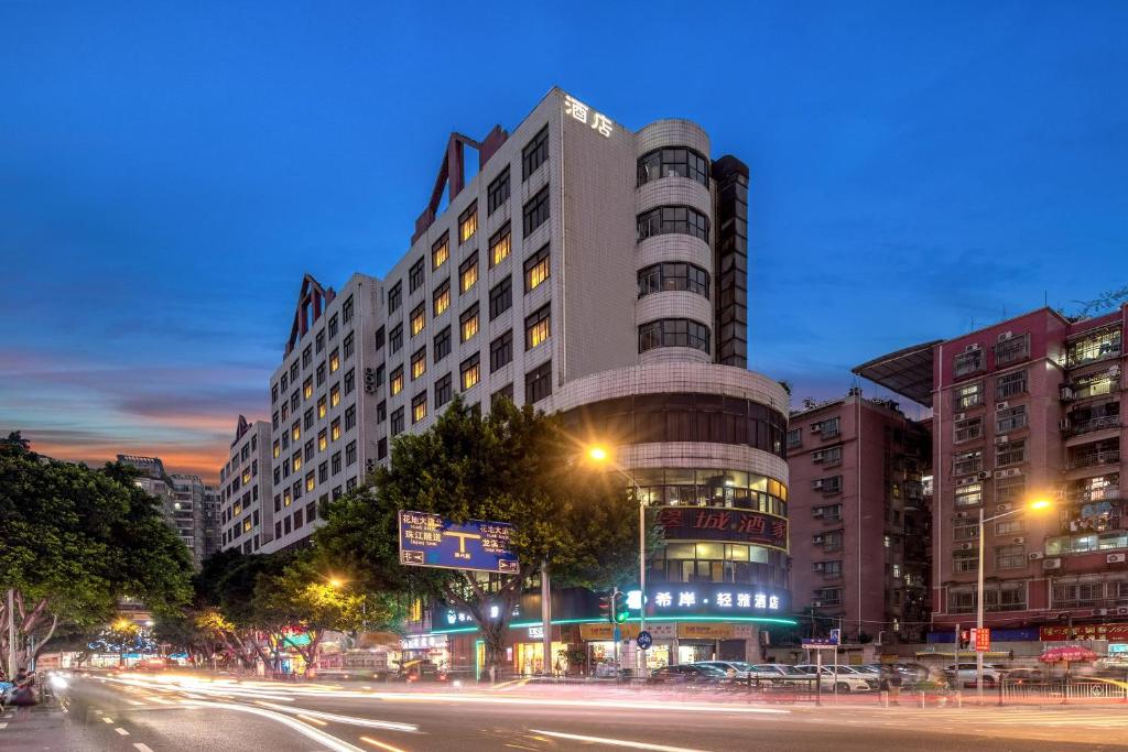 a large building on a city street at night at Xana Lite Hotel - Guangzhou Fangcun Huadiwan Metro Station in Guangzhou