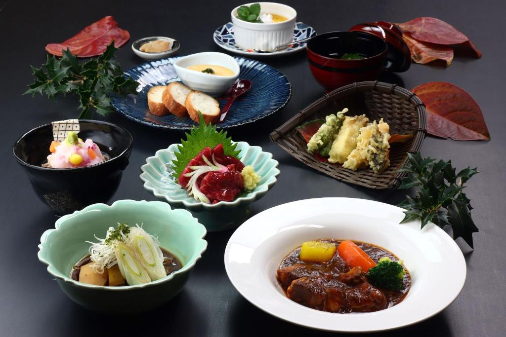 una mesa cubierta con tazones de comida en una mesa en Baigetsu Ryokan, en Shimo-suwa
