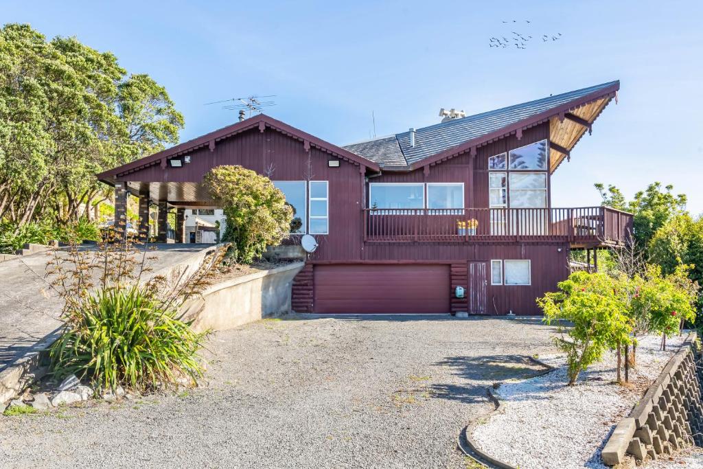 a wooden house with a garage and a driveway at Eclectic 70s Mansion in Wellington