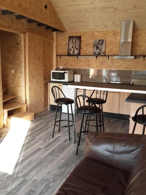 a kitchen with bar stools and a counter top at Cabane perchée in Saint-Brieuc