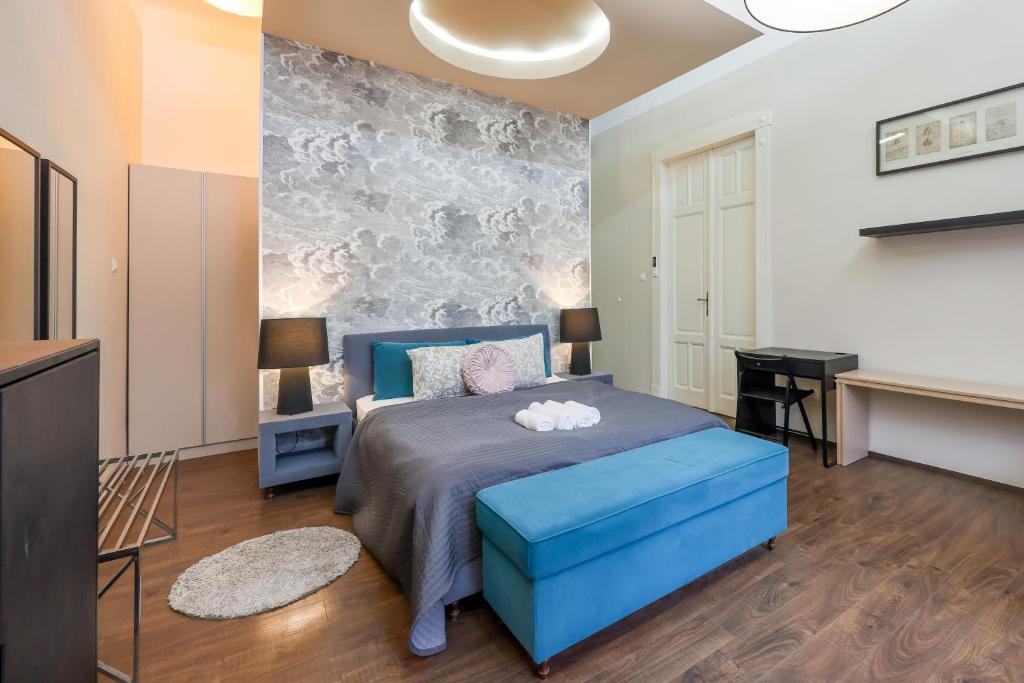 una camera con un letto blu e un ottomano blu di Deluxe Central Apartment with 4BEDRM 2 BATHRM a Budapest