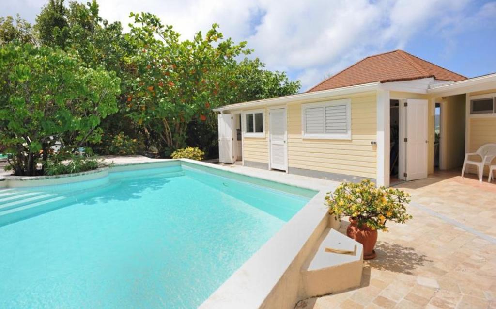 a swimming pool in front of a house at Saint Barth Villa 7 in Pointe Milou