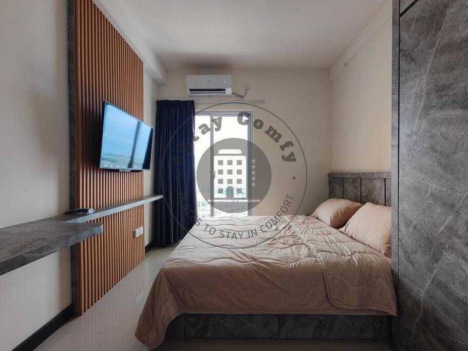 um quarto com uma cama e uma televisão de ecrã plano em Studio Citra Plaza Nagoya A2718 City and Sea View em Jodoh
