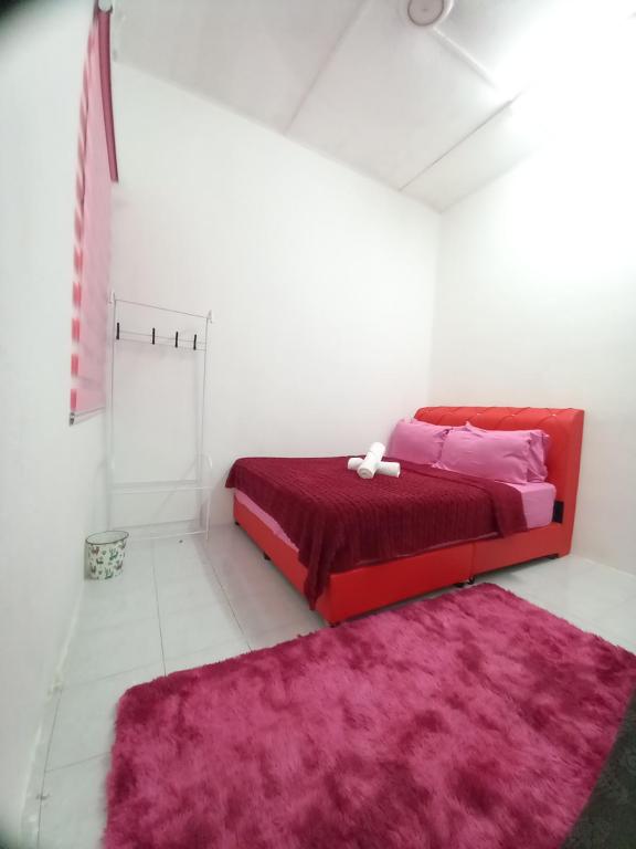 een slaapkamer met een rood bed en een roze tapijt bij Yong's Stay Sri Manjung in Seri Manjung
