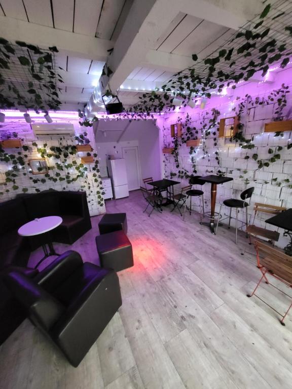Zimmer mit Tischen, Stühlen und violetten Lichtern in der Unterkunft Kuca na reci za zurke MARiLYN MONROE in Belgrad