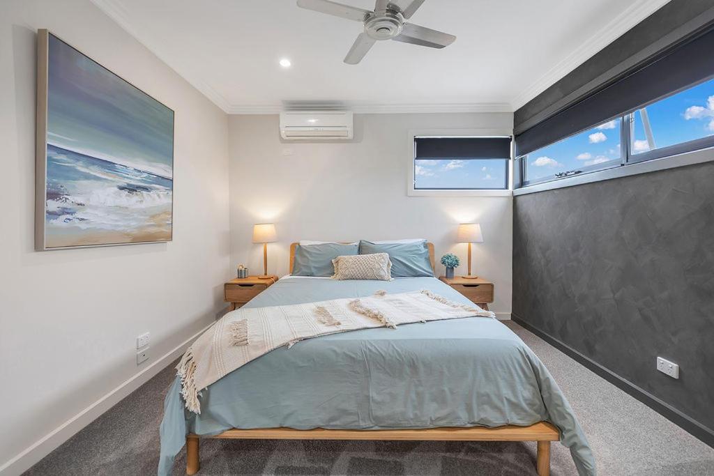 a bedroom with a bed and two windows at Studio237 Kyabram in Kyabram