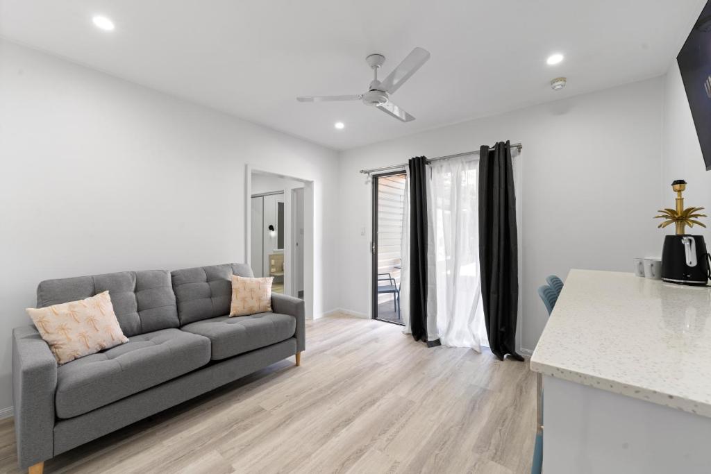 a living room with a couch and a kitchen at Caravella Backpackers in Cairns