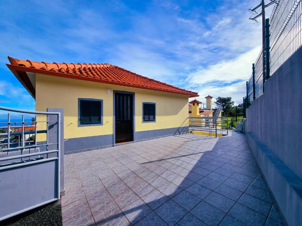 mały żółty dom z czerwonym dachem w obiekcie En Santana centro, casa con vista al mar y la montaña w mieście Santana