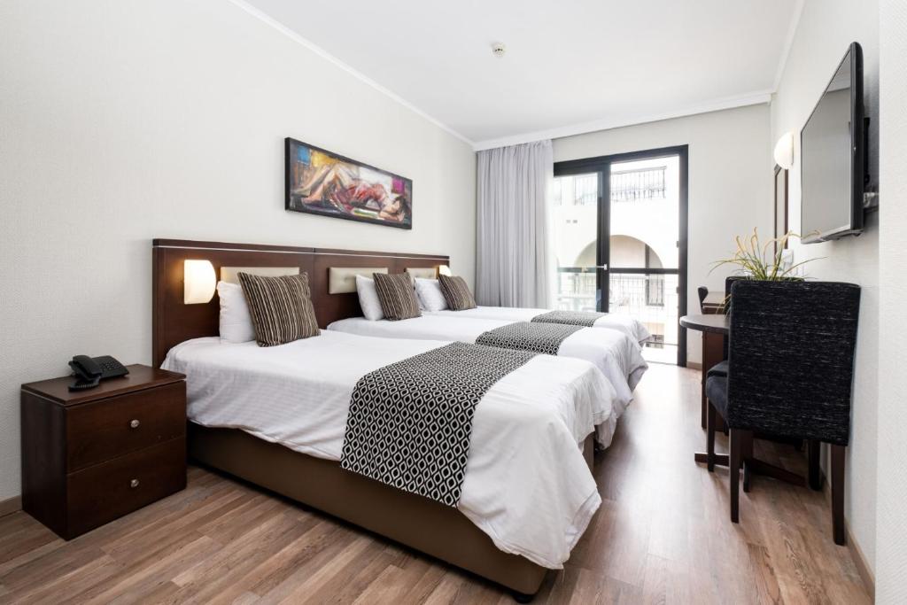 Postel nebo postele na pokoji v ubytování Livadhiotis City Hotel