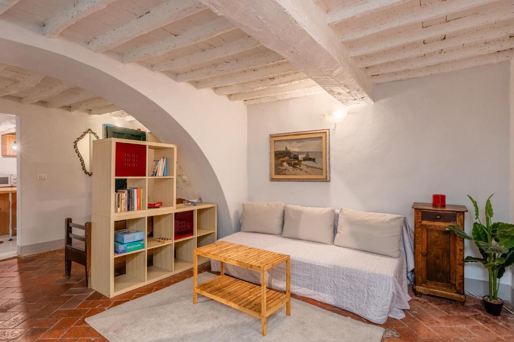 a living room with a bed and a book shelf at Elisa loft davanti alle Mura Lucca in Lucca
