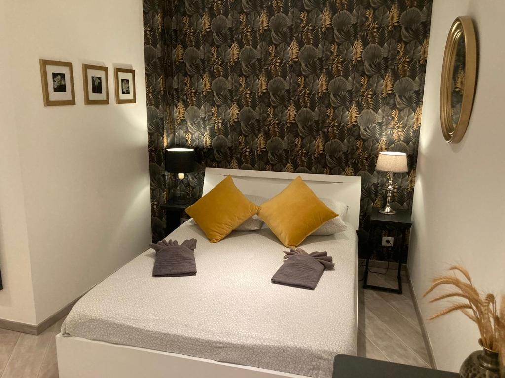a bedroom with a bed with yellow pillows at "LES ALIZES" Côté jardin Proche Bord de mer in Saint-Raphaël