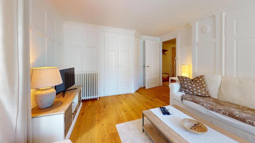 un soggiorno con divano e TV di Apartment Chavallera 5 a Sankt Moritz