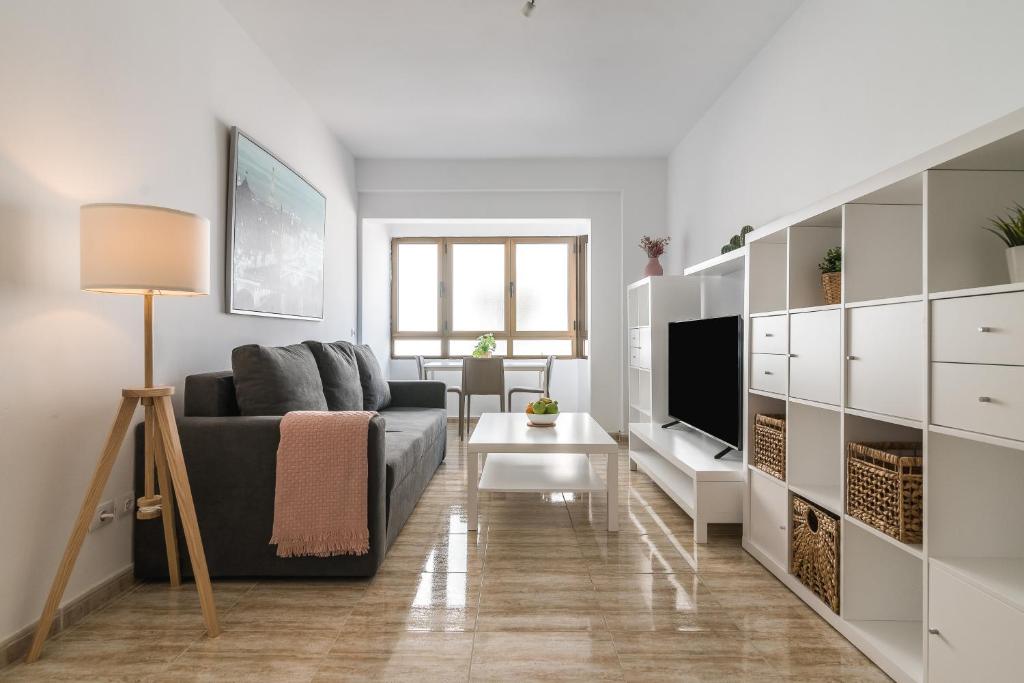 uma sala de estar com um sofá e uma televisão em Home2Book Charming Apartments La Naval La Isleta em Las Palmas de Gran Canaria