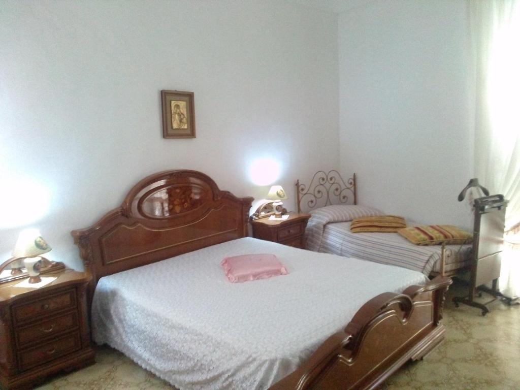 a bedroom with two beds and a pink pillow on the bed at Casa Leone in Noto