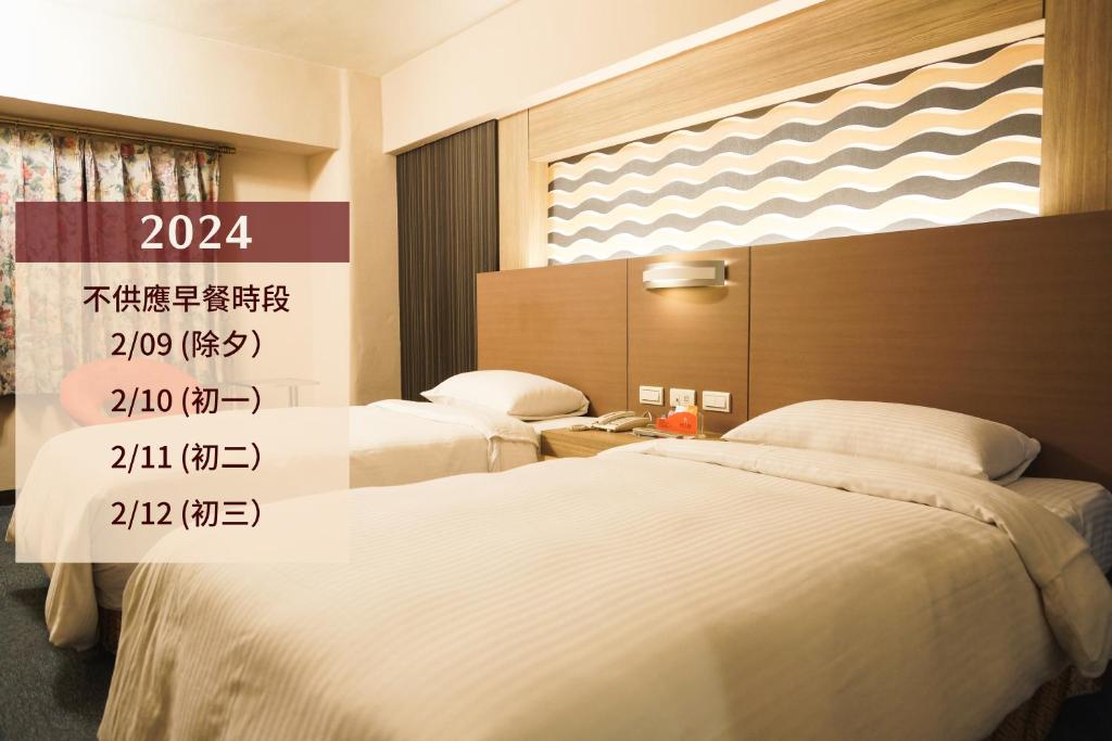 2 camas en una habitación de hotel con en Ying Dai Hotel, en Tainan