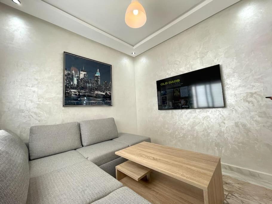 uma sala de estar com um sofá e uma mesa em A3 Appartement entièrement neuf au cœur de Témara em Temara