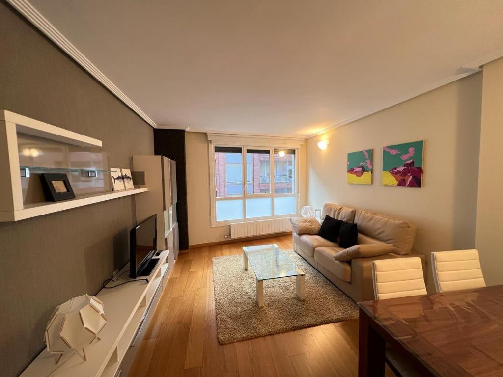 a living room with a couch and a tv at ELCANO Bermeo 2 in Bermeo