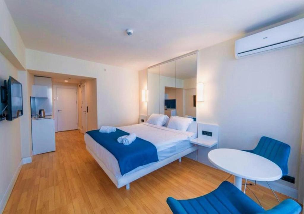 a bedroom with a bed and a table and chairs at Beachfront Apartments Batumi in Batumi
